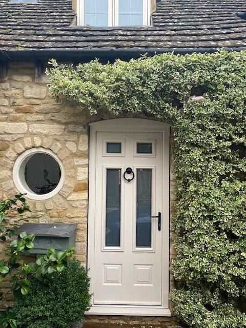 Cream composite front door on a stone cottage